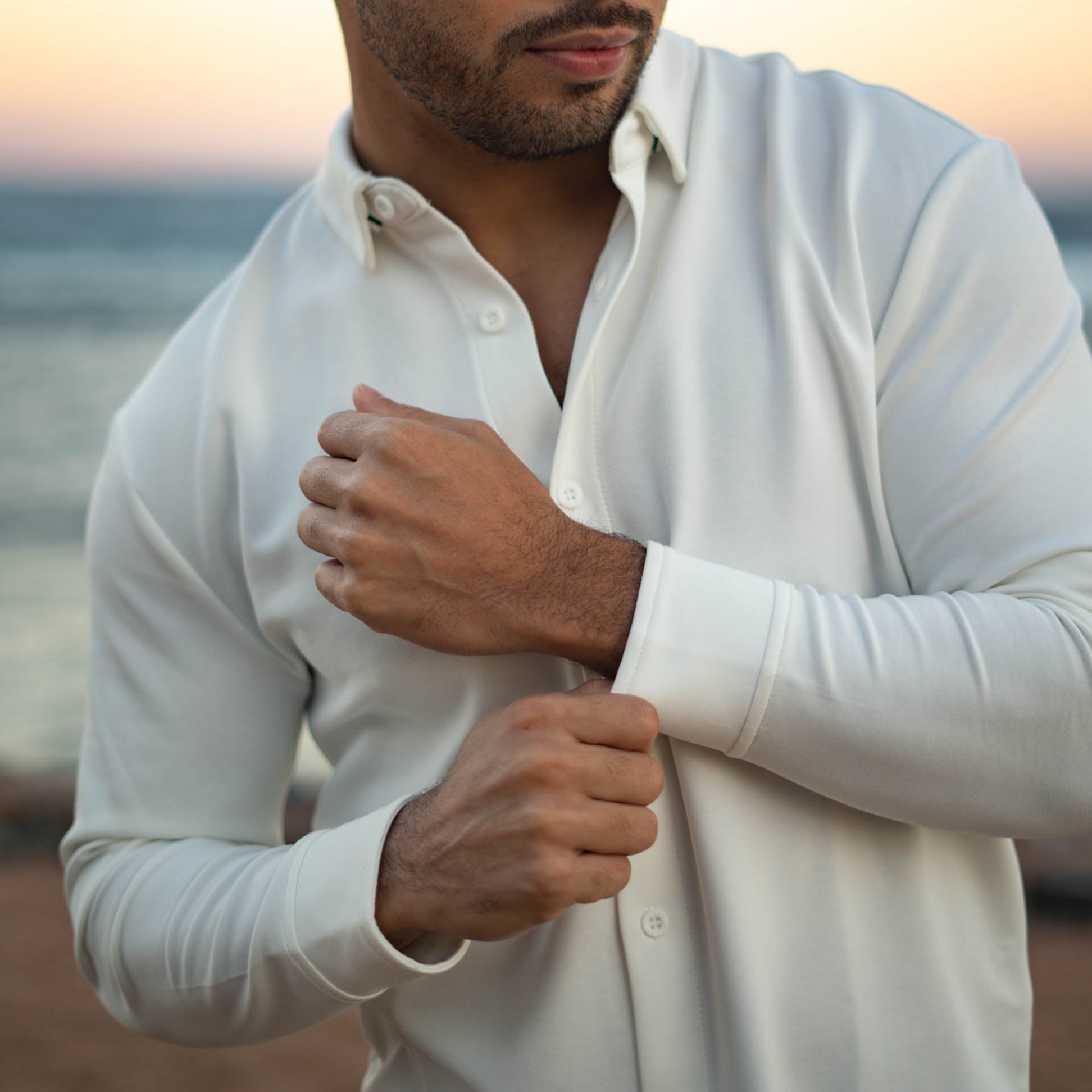 Male model wearing a white flex button down shirt for short men from under510.com